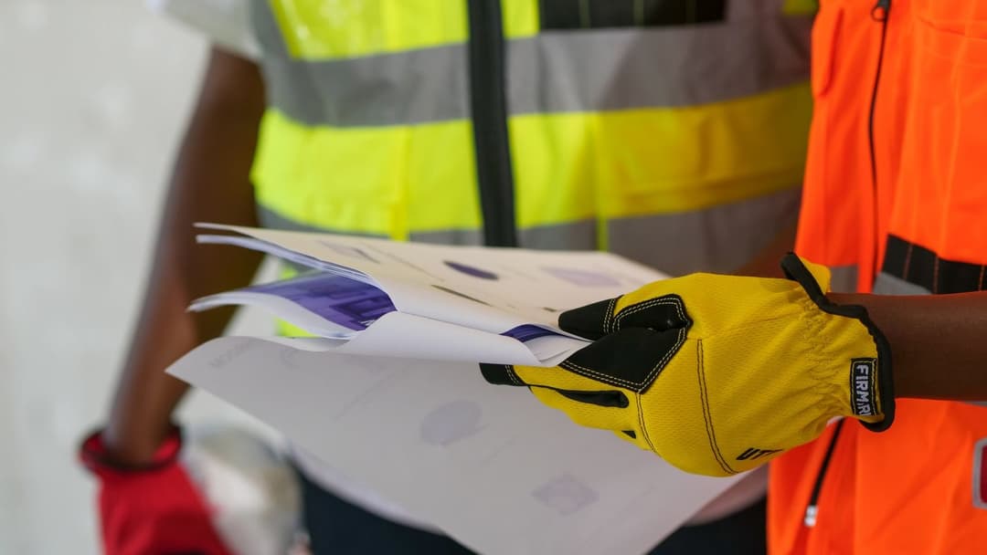 Professionnels du chantier relisant un détail quantitatif estimatif et ses documents