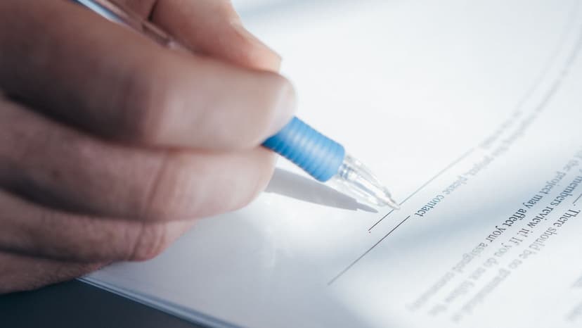Main signant un document administratif au stylo, formulaires DC1 et DC2 d'un marché public