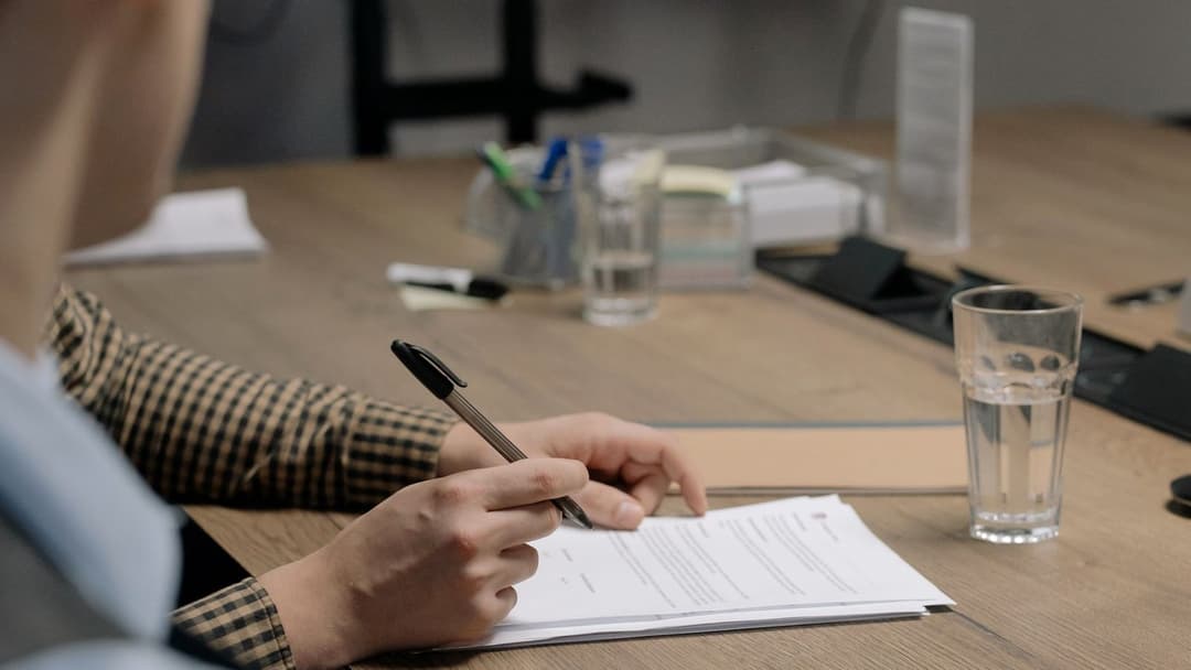 Signature d'un document contractuel sur un bureau en bois, DUME pour un marché public européen