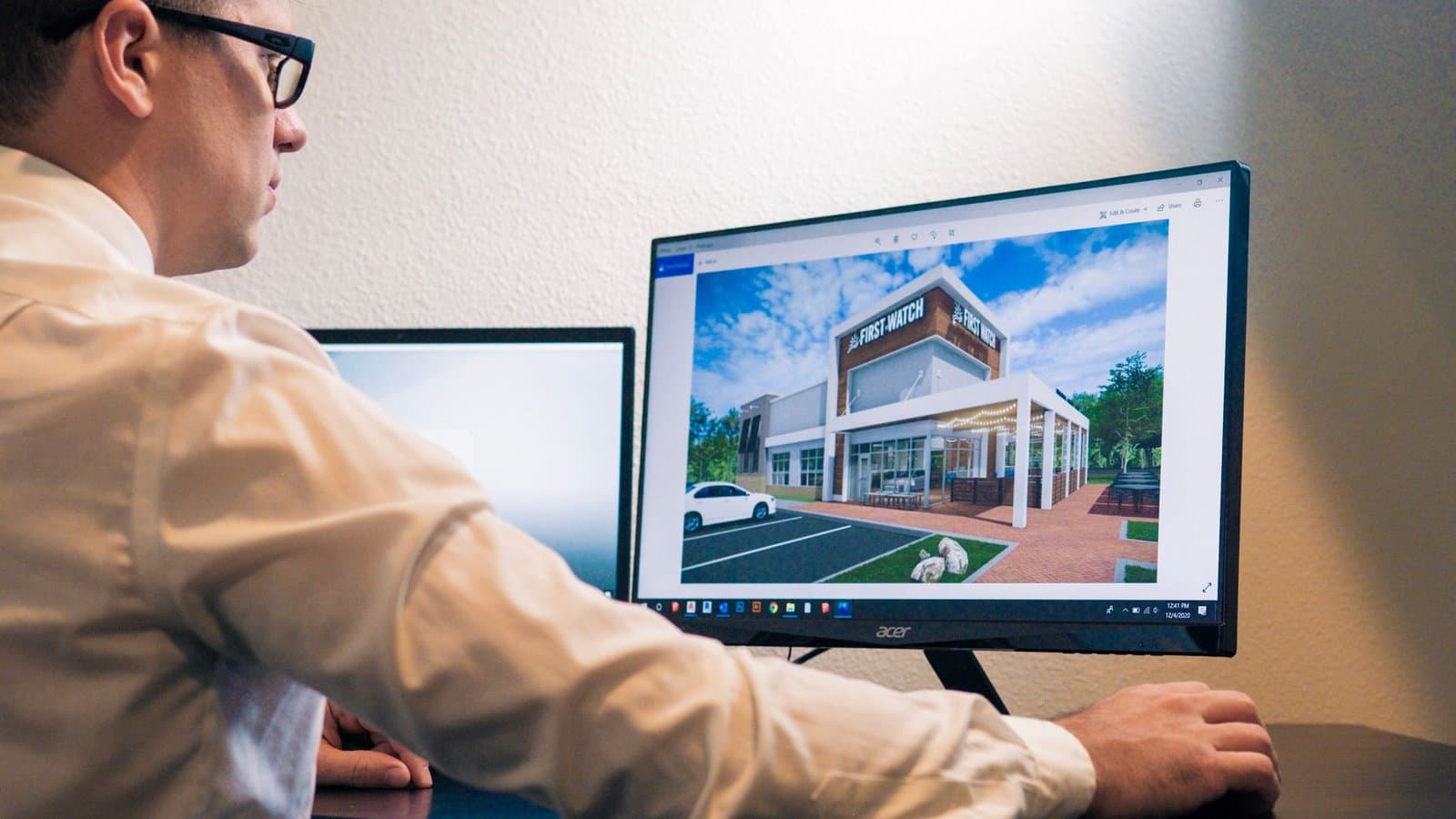 Architecte examinant une conception de bâtiment à l'écran avec un logiciel de rendu 3D d'architecture
